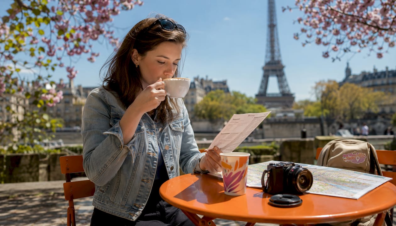 Woman planning trip near Eiffel Tower café
