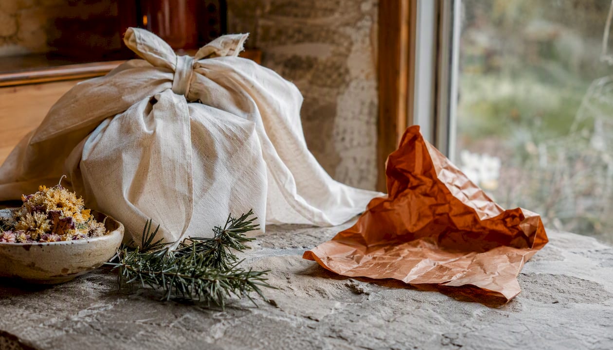 Reusable fabric wrap beside torn disposable paper