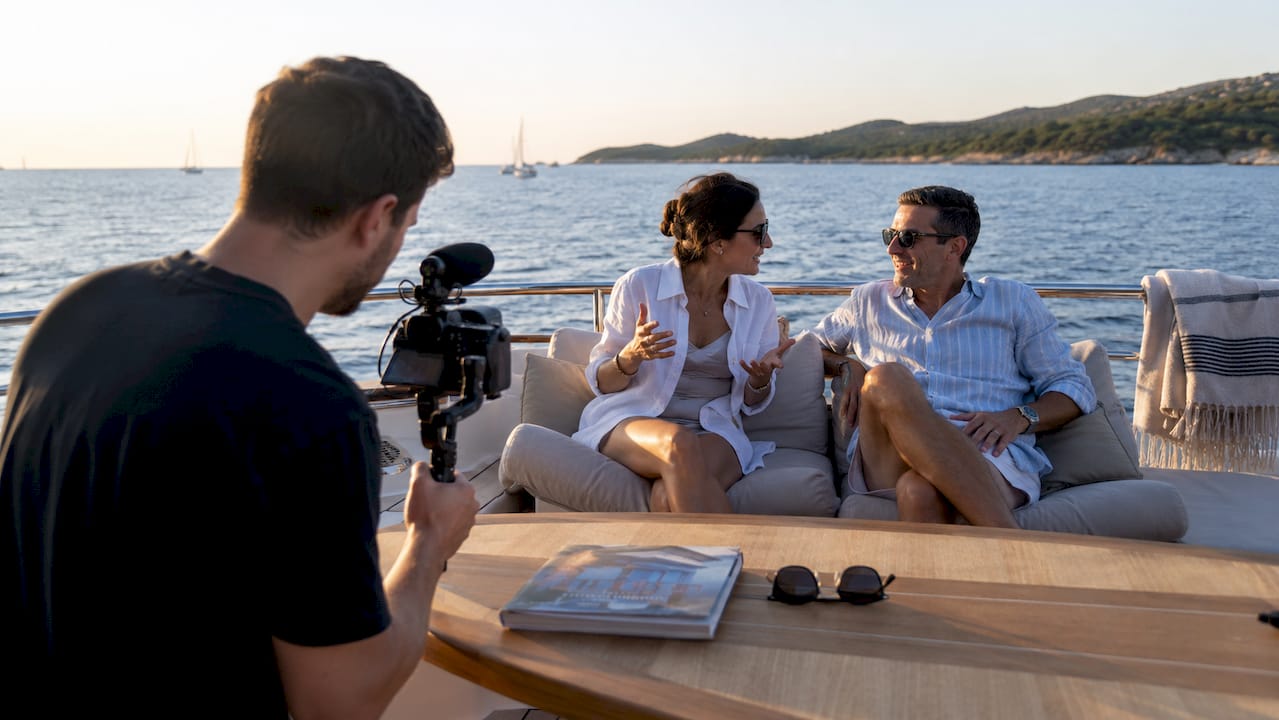 Video technician filming clients on yacht