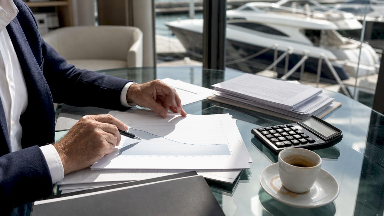 Hands analyzing yacht depreciation chart