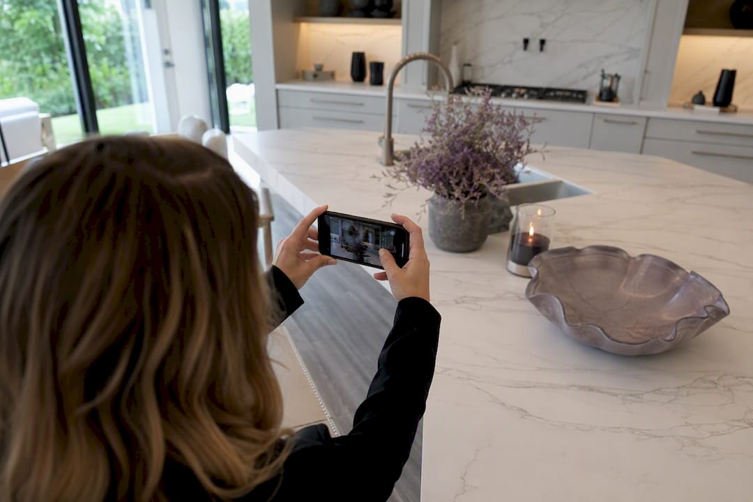 Hands filming luxury home video on smartphone