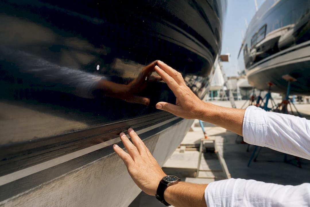 Surveyor inspecting yacht hull surface