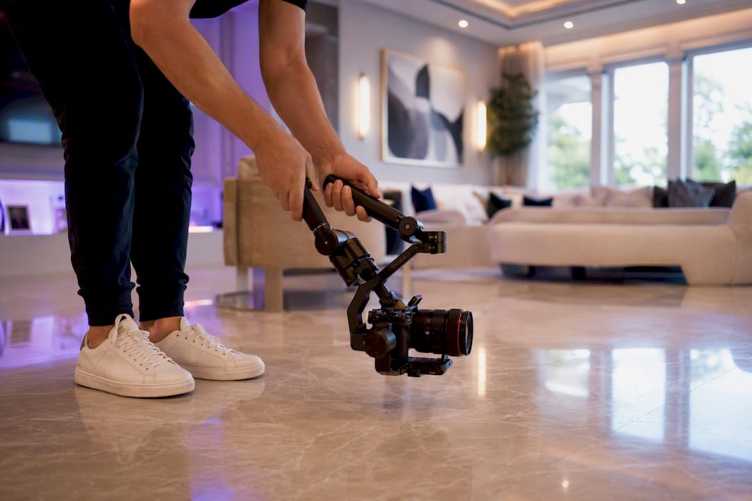 Hands operating video gimbal for home walkthrough