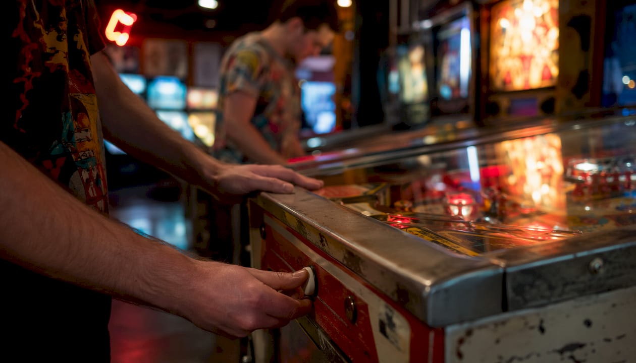 Close-up of hands playing licensed pinball machine