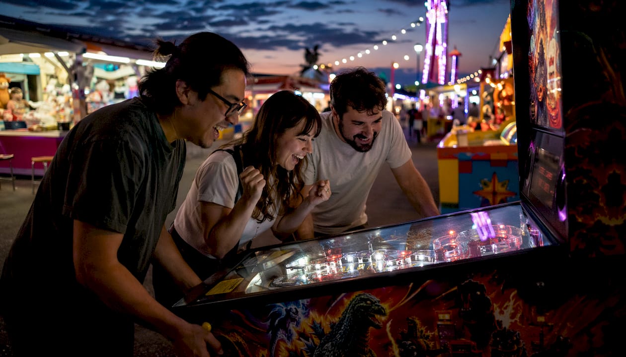 Group playing Limited Edition Godzilla pinball machine
