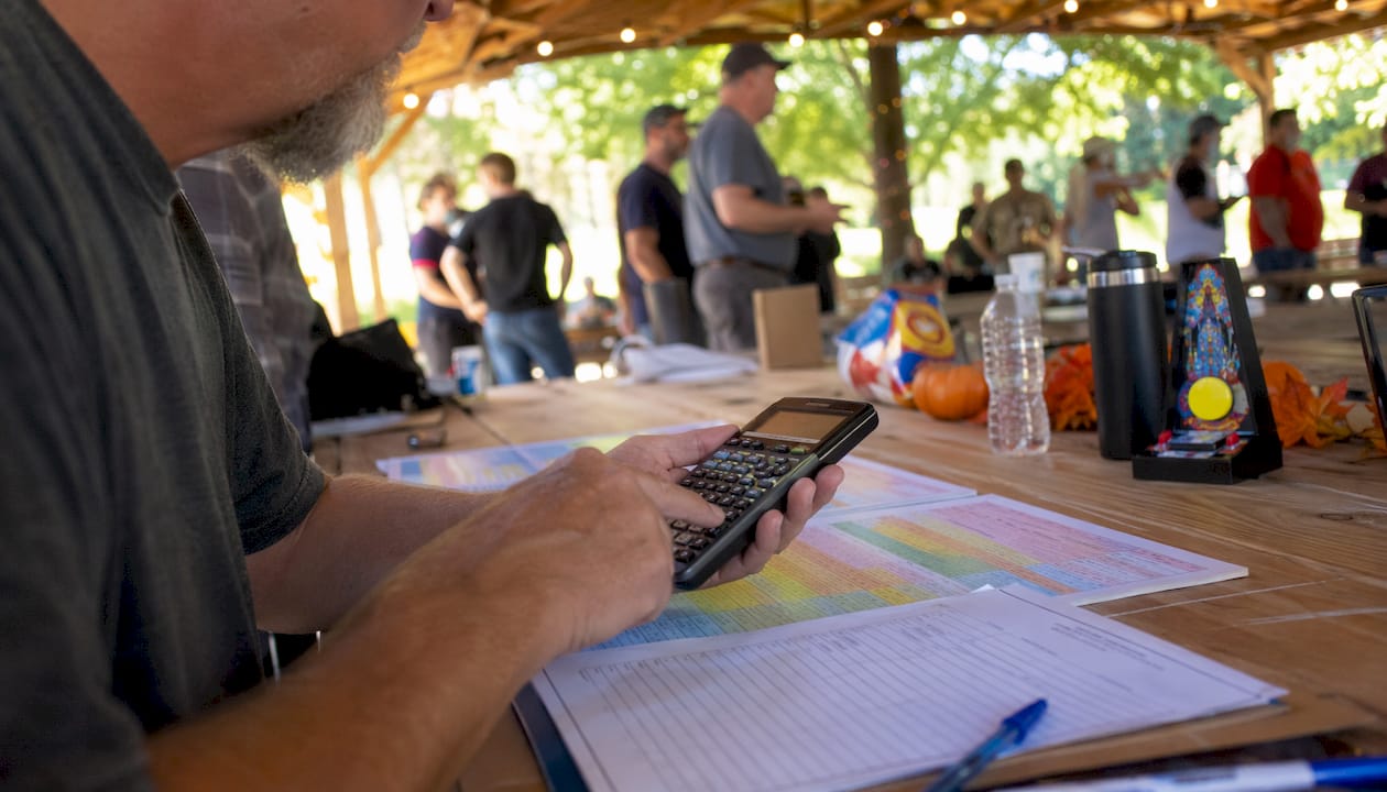 Hands calculating pinball tournament scores