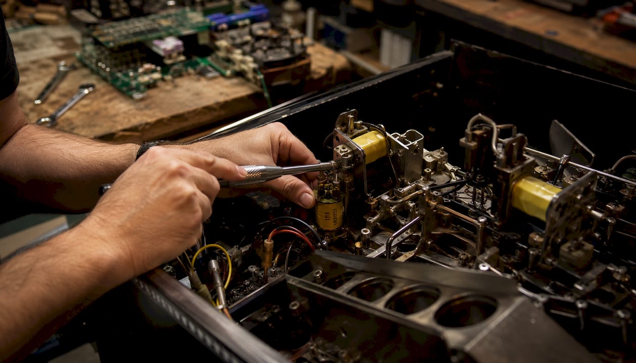 Close-up of pinball lock mechanism being repaired