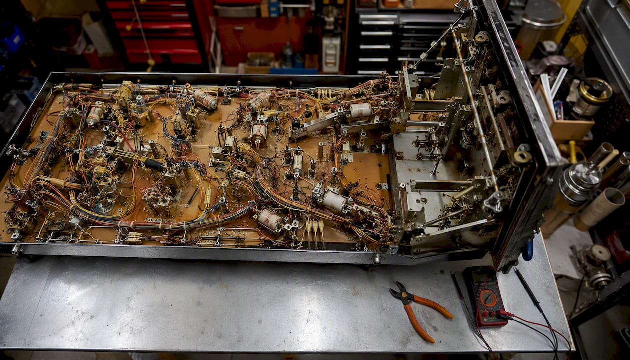 Underside of pinball playfield showing wiring and solenoids