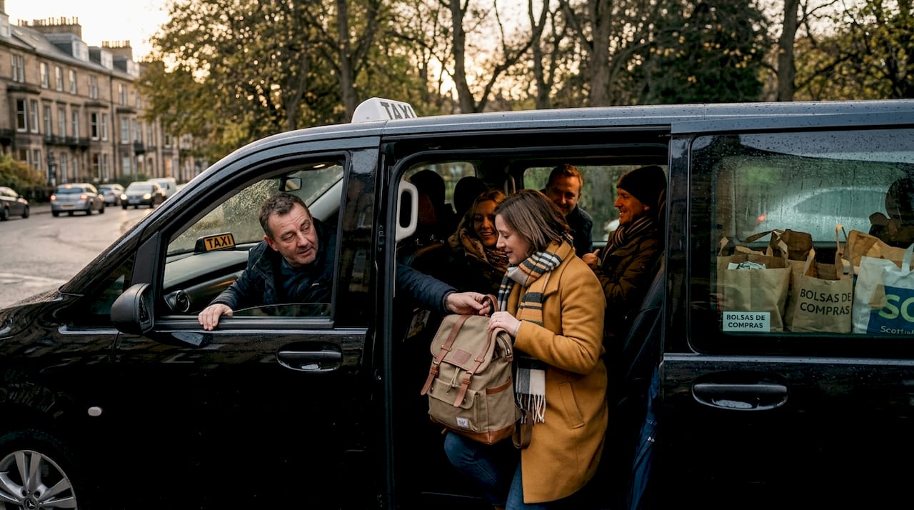 Un grupo de personas se sube a un taxi grande en Edimburgo