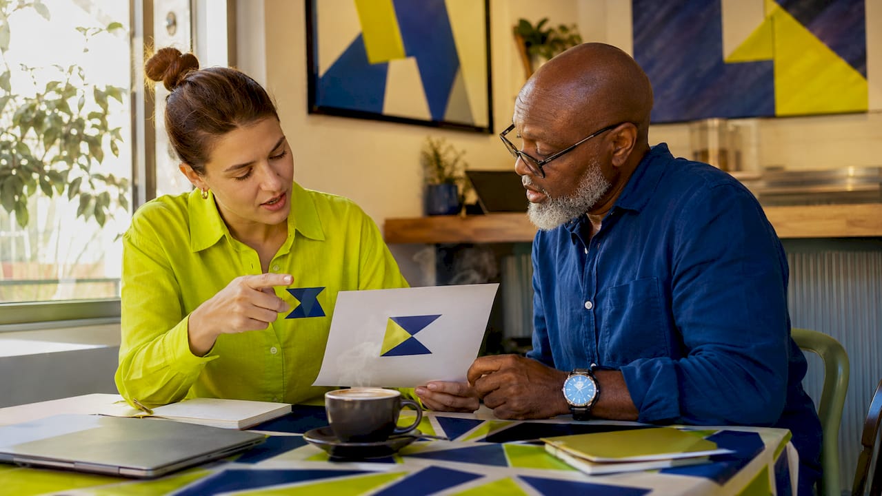 Overhead of two people comparing logo and favicon prints