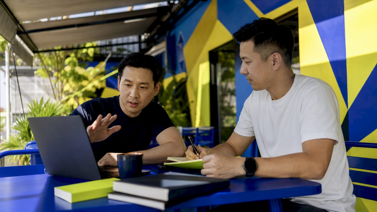 Two men collaborating on SEO strategy at coworking table