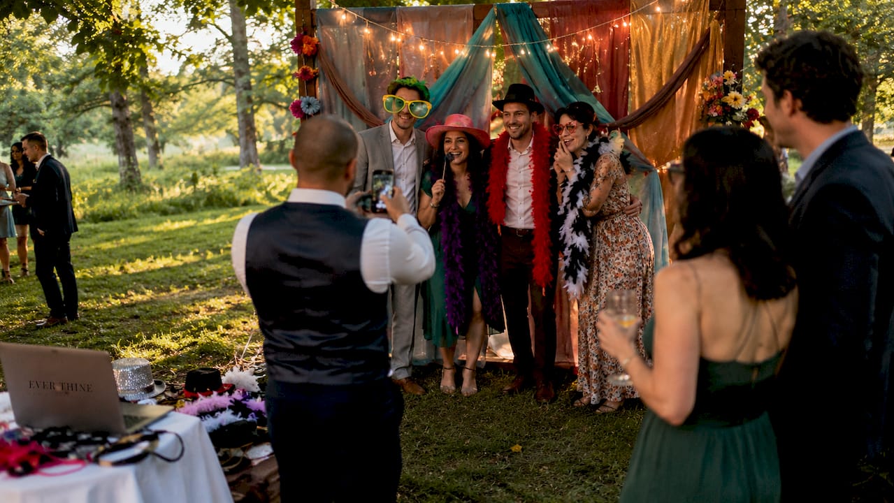 Guests enjoying DIY wedding photo booth outdoors