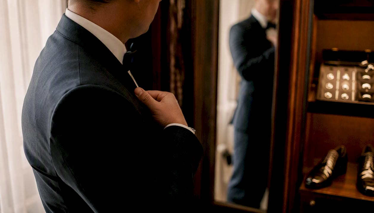 Groom checking shoulder fit of suit