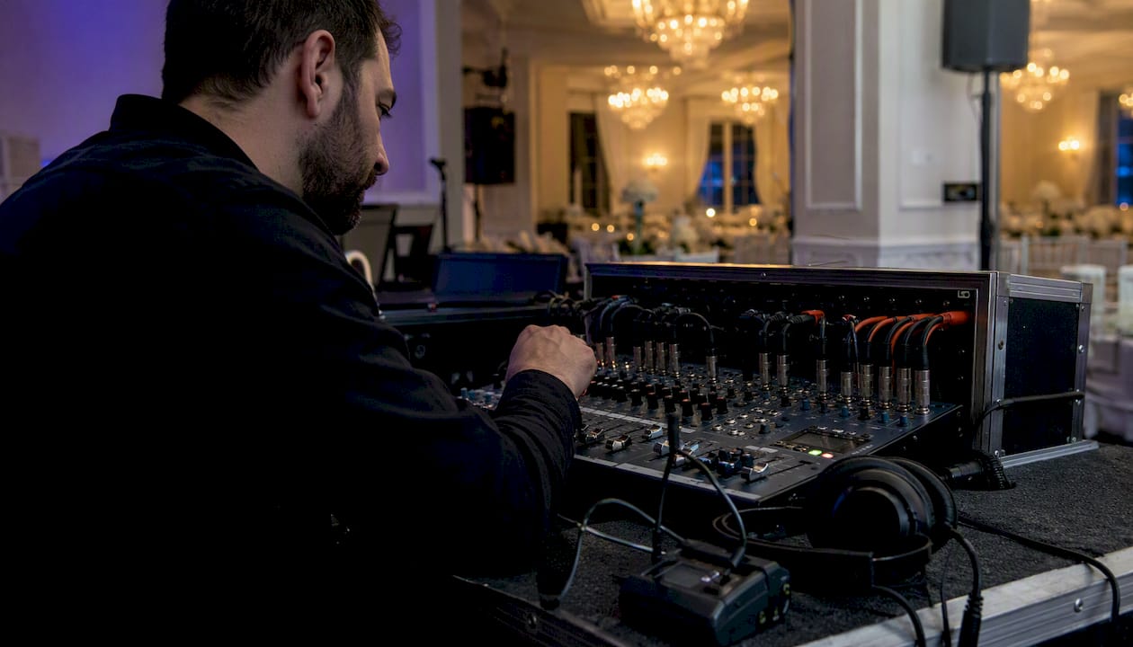Sound engineer adjusting audio mixer at wedding