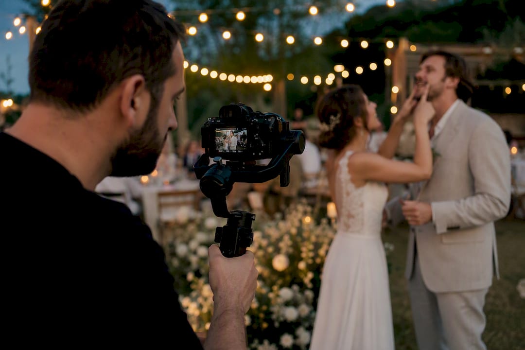 Videographer filming candid wedding moment outdoors