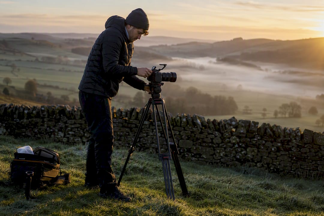 Videographer setting up camera in UK countryside