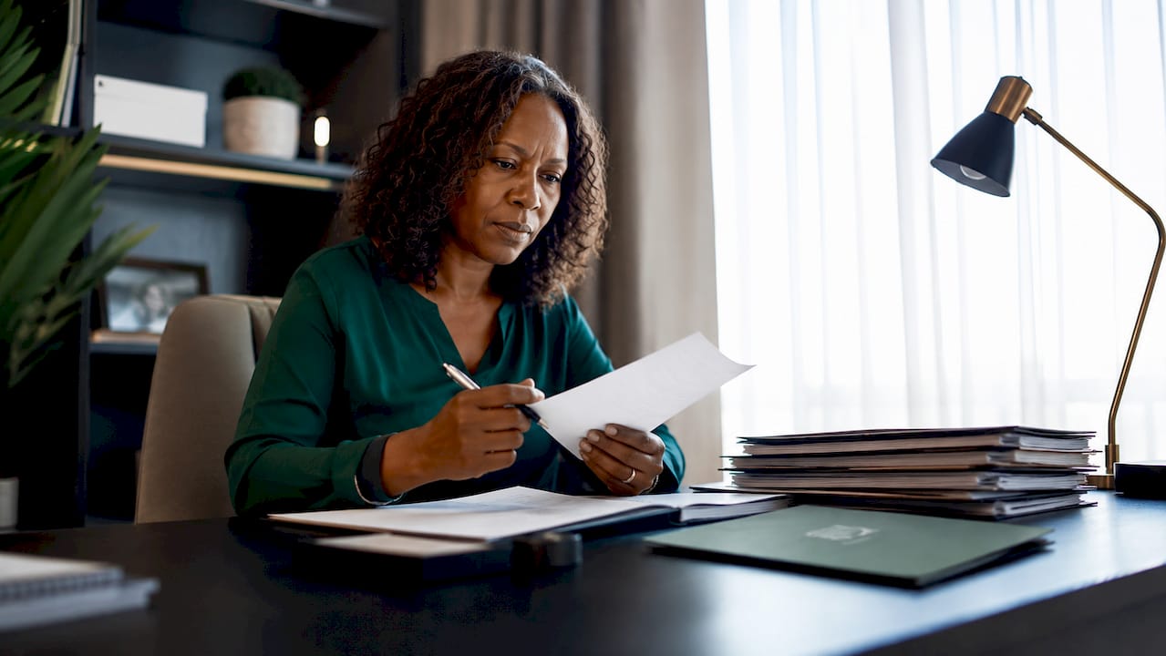 Woman reviewing company documents at desk