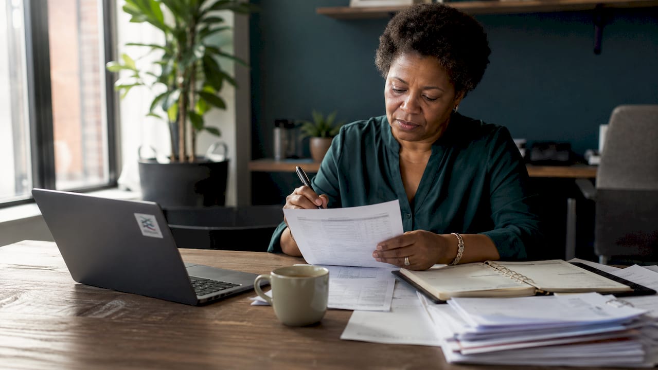Businesswoman reviewing payroll paperwork