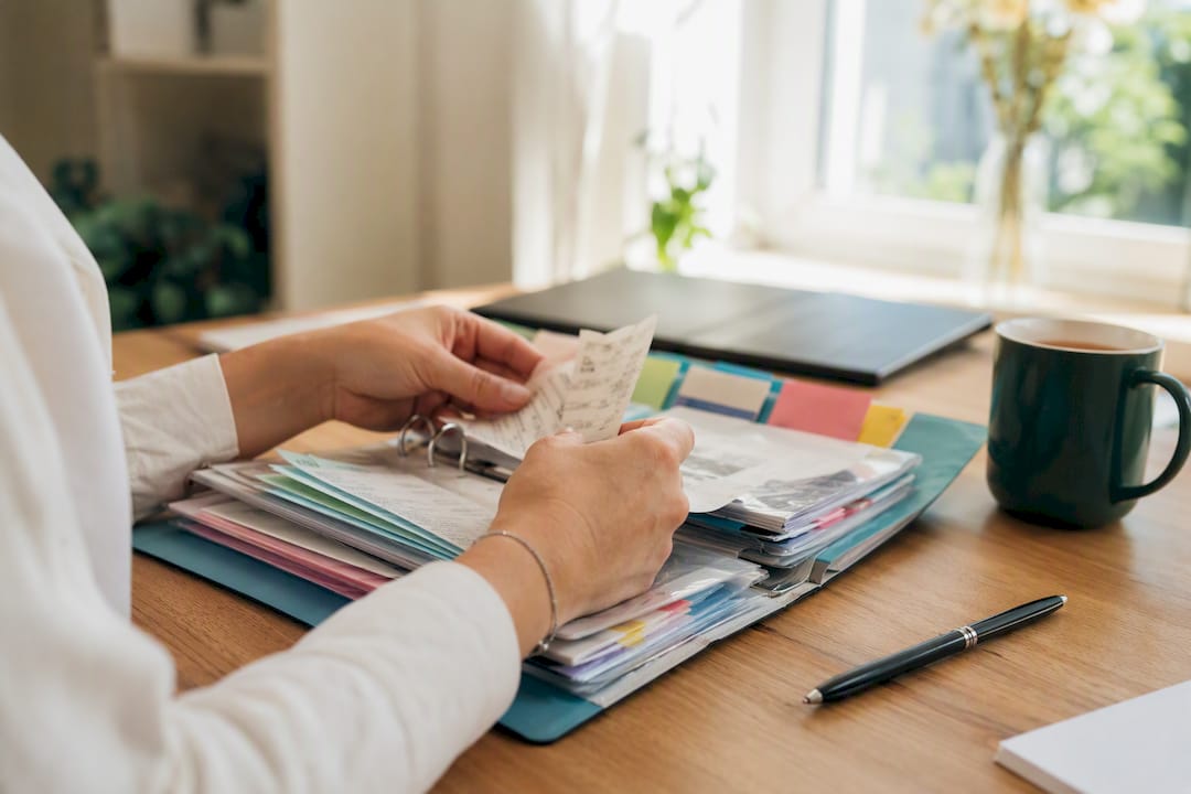 Hands filing receipts in tidy accountant workspace