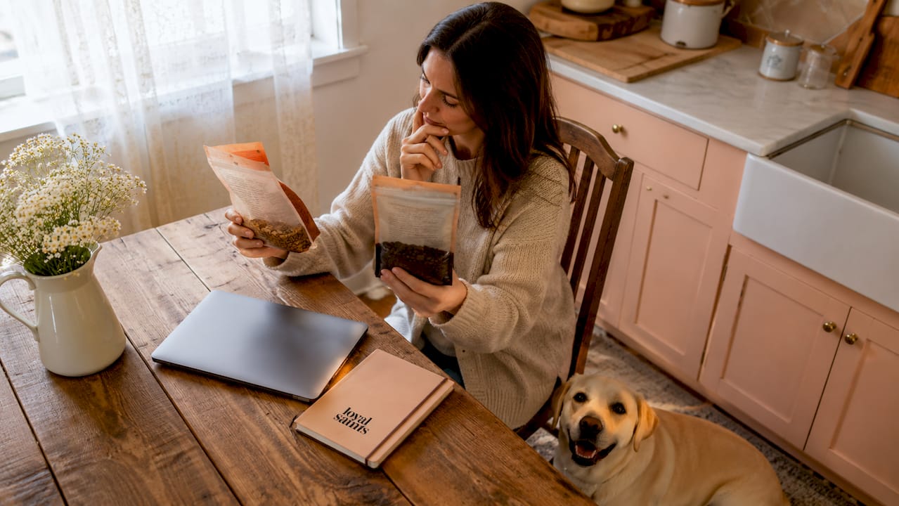 Woman comparing freeze-dried and regular dog food costs