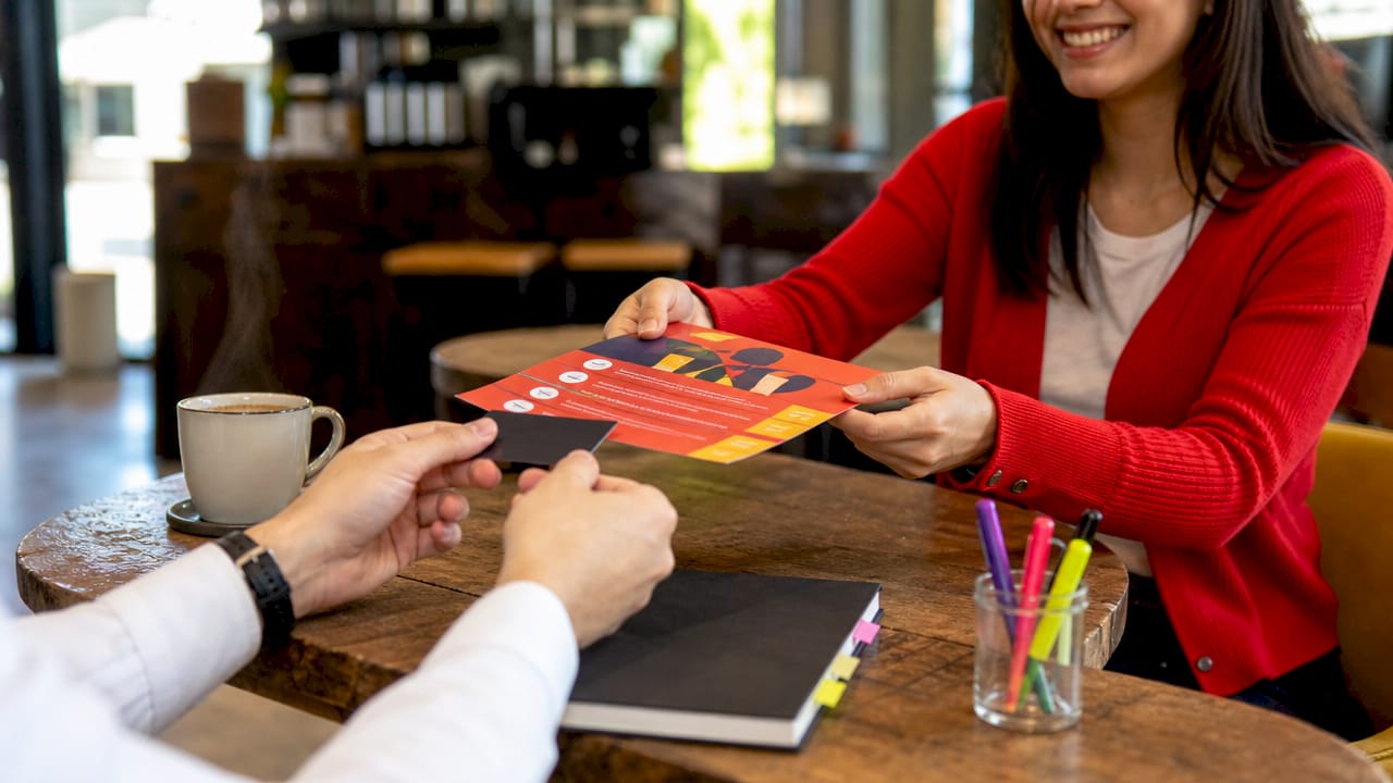 Hands exchanging checklist and business card