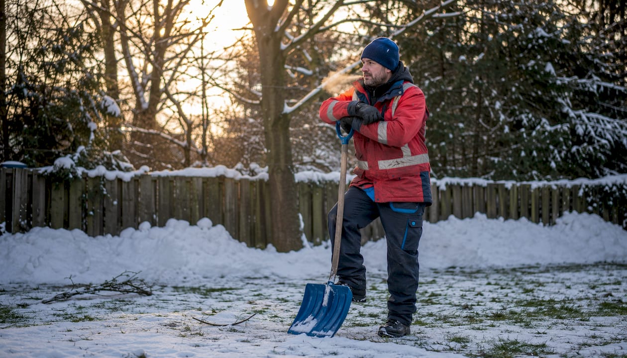 Man pausing during snow shoveling safety break