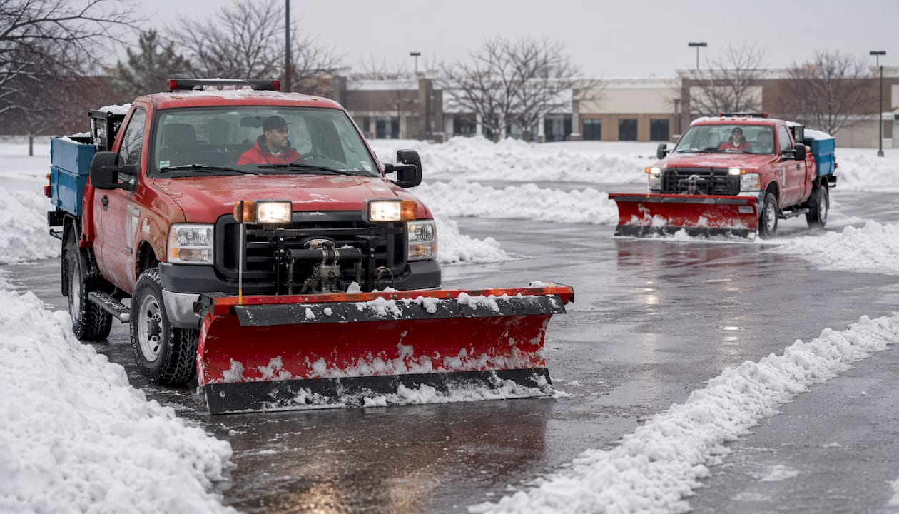Snow removal trucks clearing commercial lot