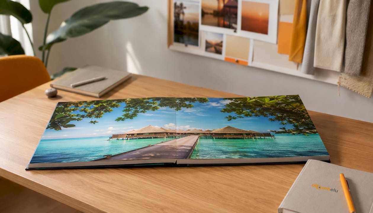 Albumul foto layflat deschis pe birou, cu fotografia principală afișată pe două pagini.