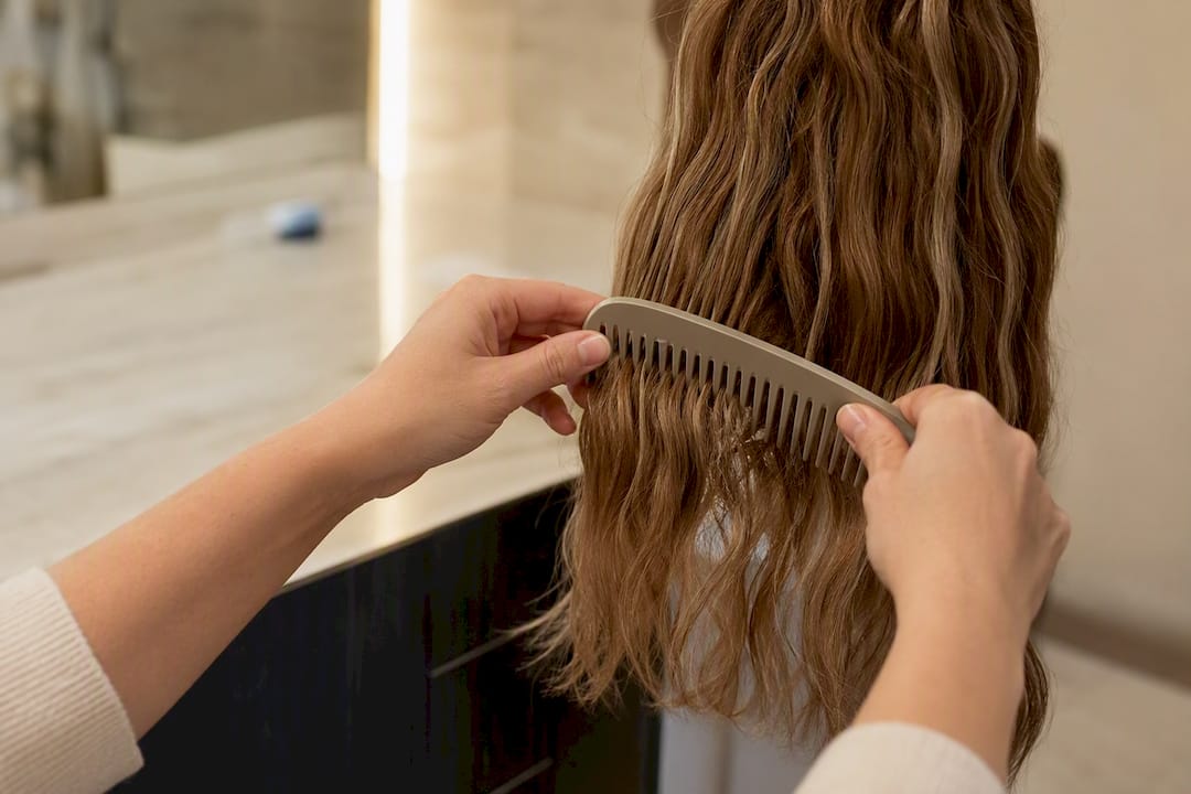 Hands detangling hair extensions from ends