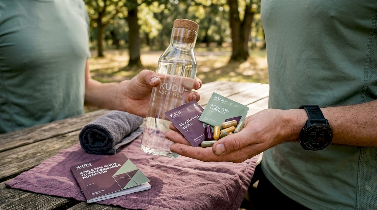 Athlete hands with hydration and supplements in gym