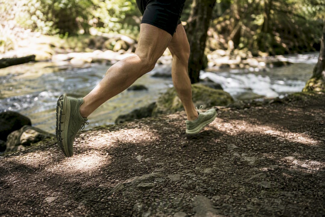 Runner legs mid-stride on trail