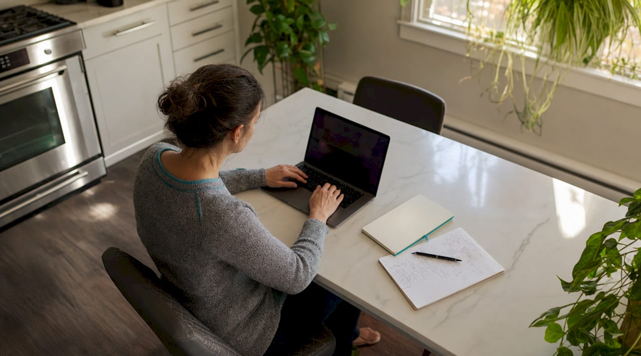 Eine berufstätige Frau arbeitet konzentriert am Laptop und importiert dabei Daten.
