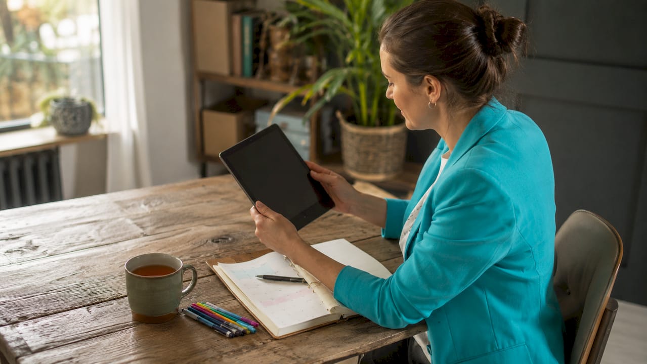 Eine Frau plant ihre Ressourcen digital auf dem Tablet.