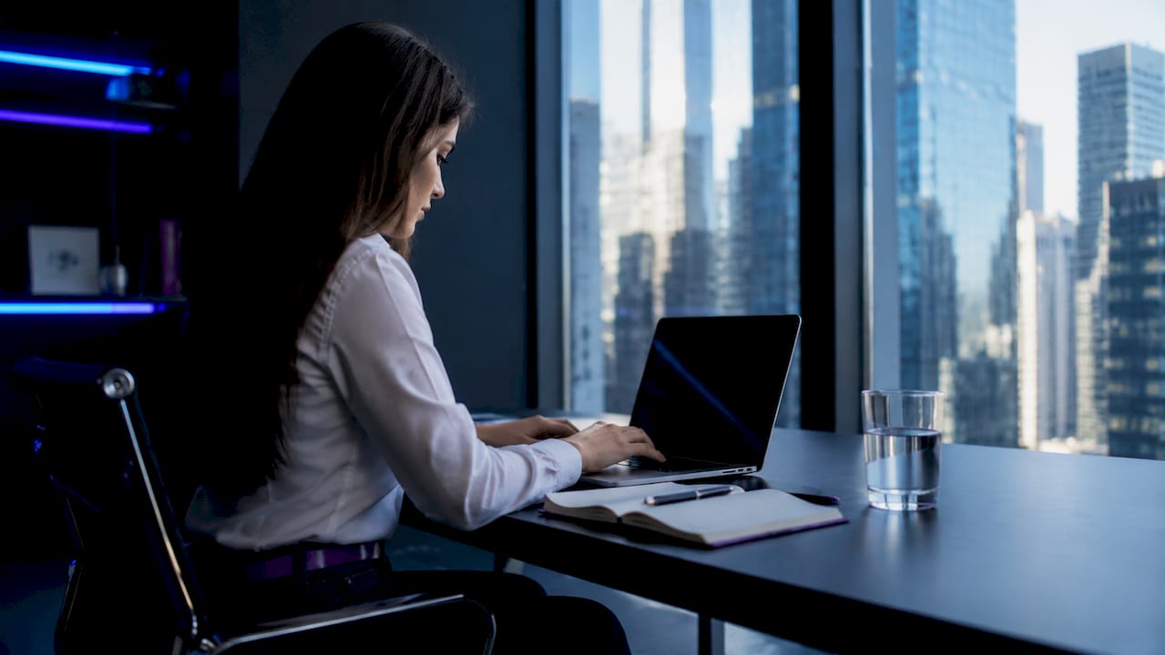 Woman typing crypto investment goals in café