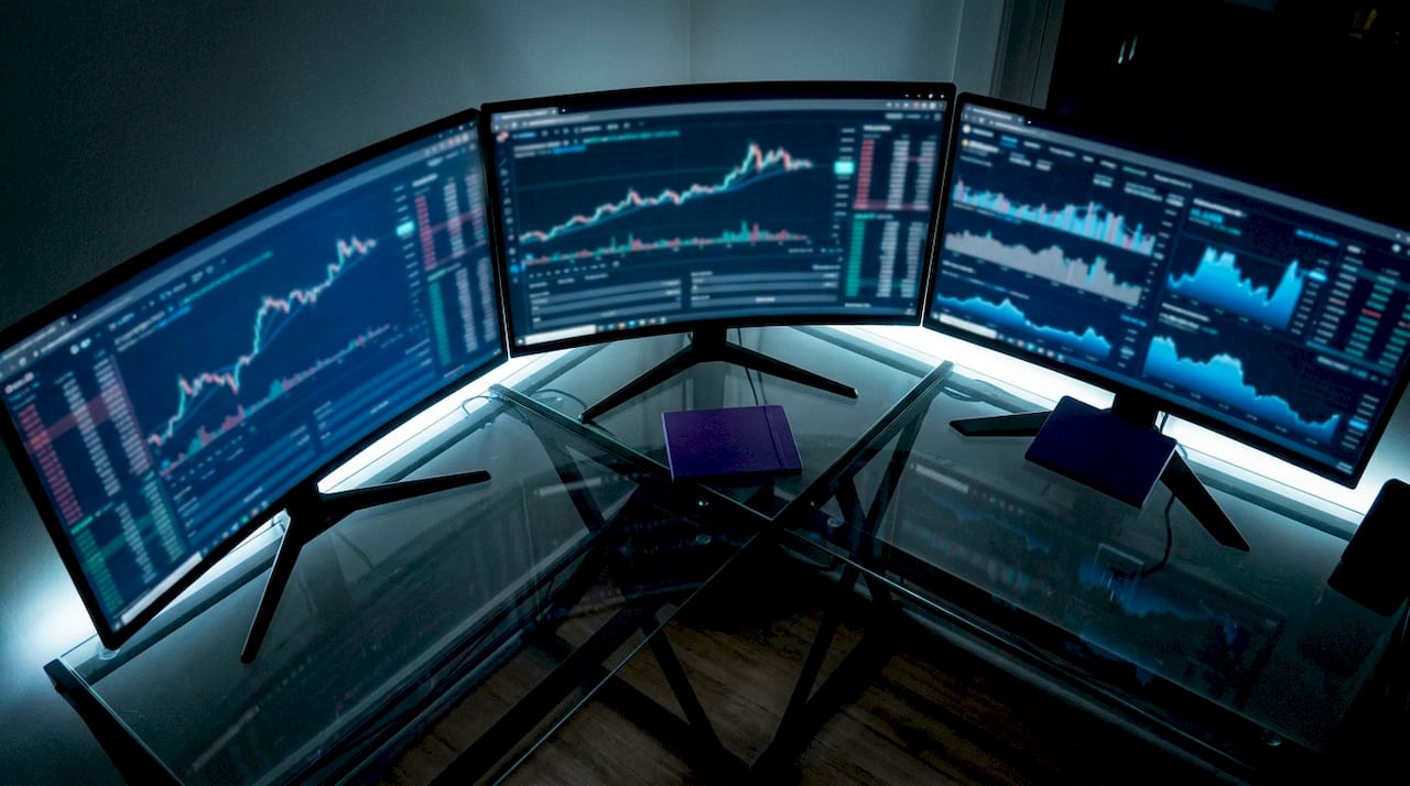 Professional AI trading desk with monitors