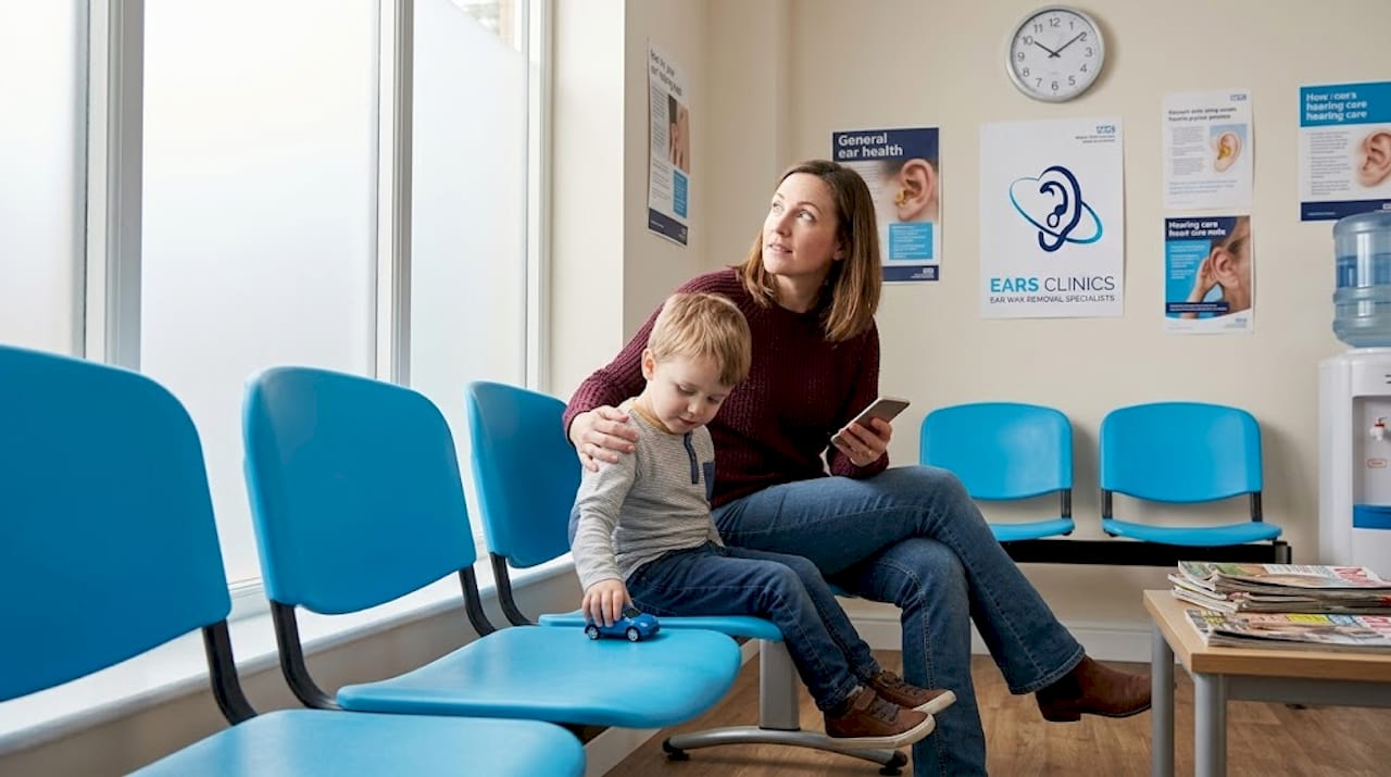 Mother and child waiting in NHS ear clinic