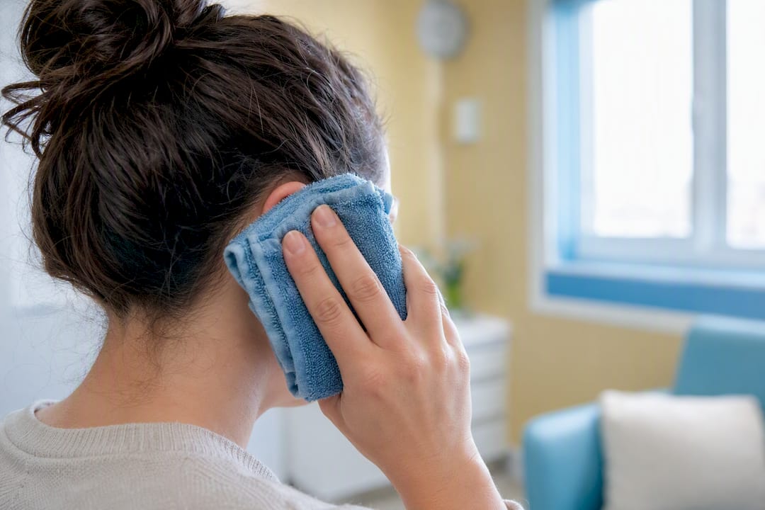 Warm compress on outer ear for pain relief