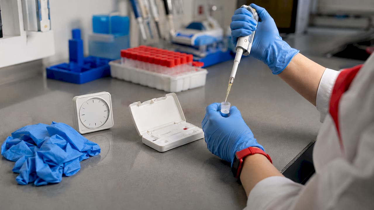 Hands preparing sample on POCT device