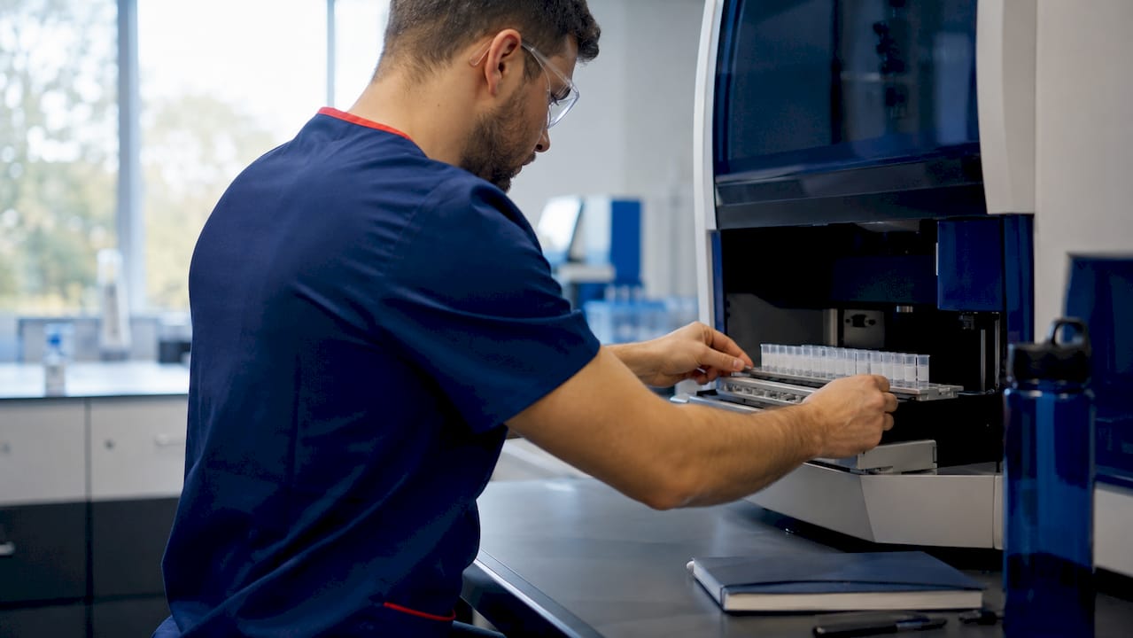 Technician loading samples into testing machine