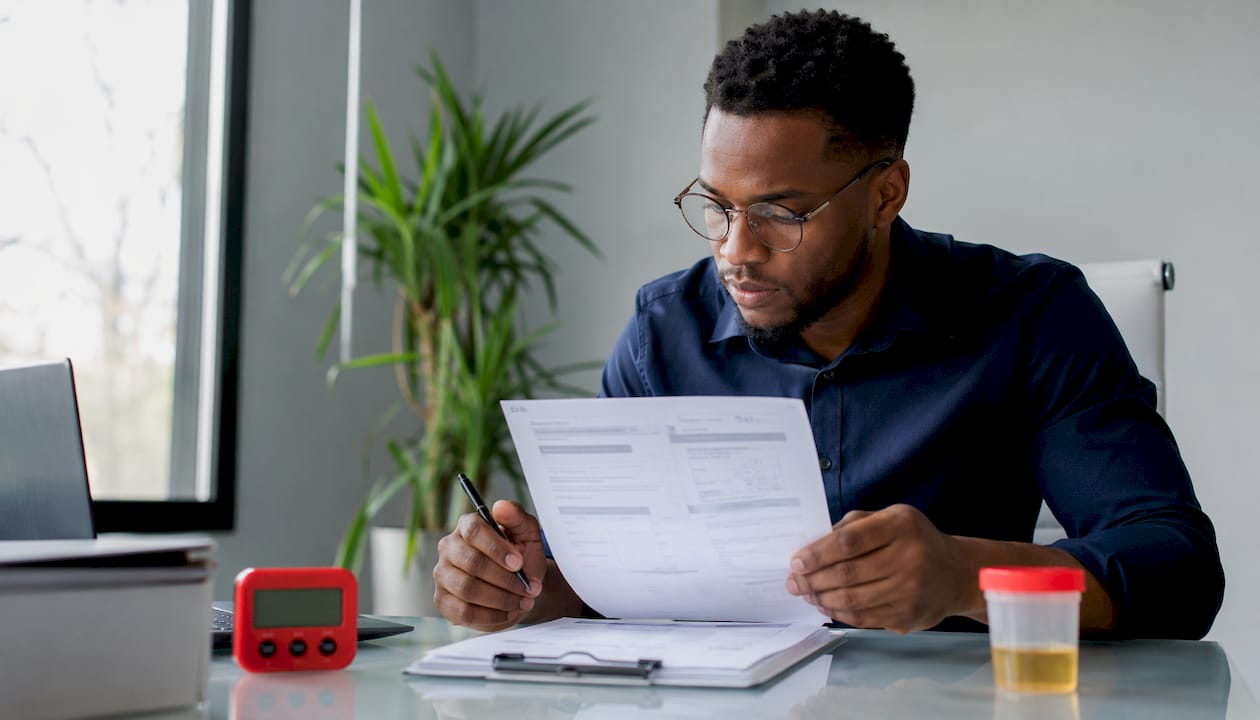 Clinician reviewing printed test reports at office desk