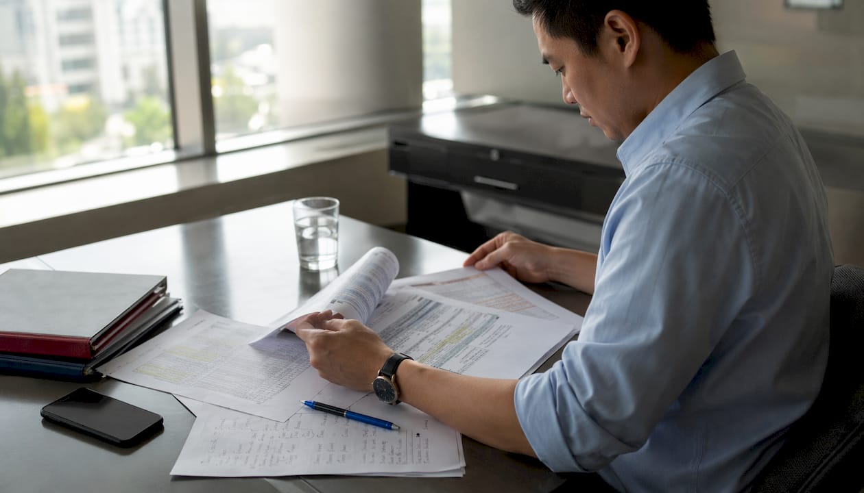 Hands reviewing compliance program metrics