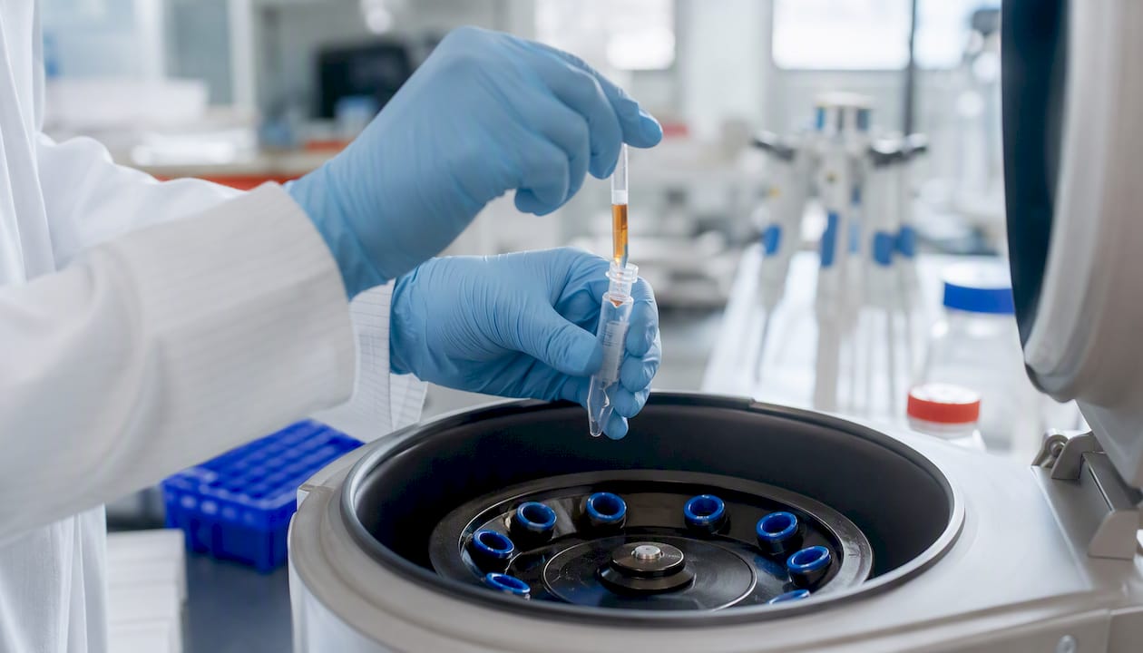 Gloved hands holding metabolic sample vial