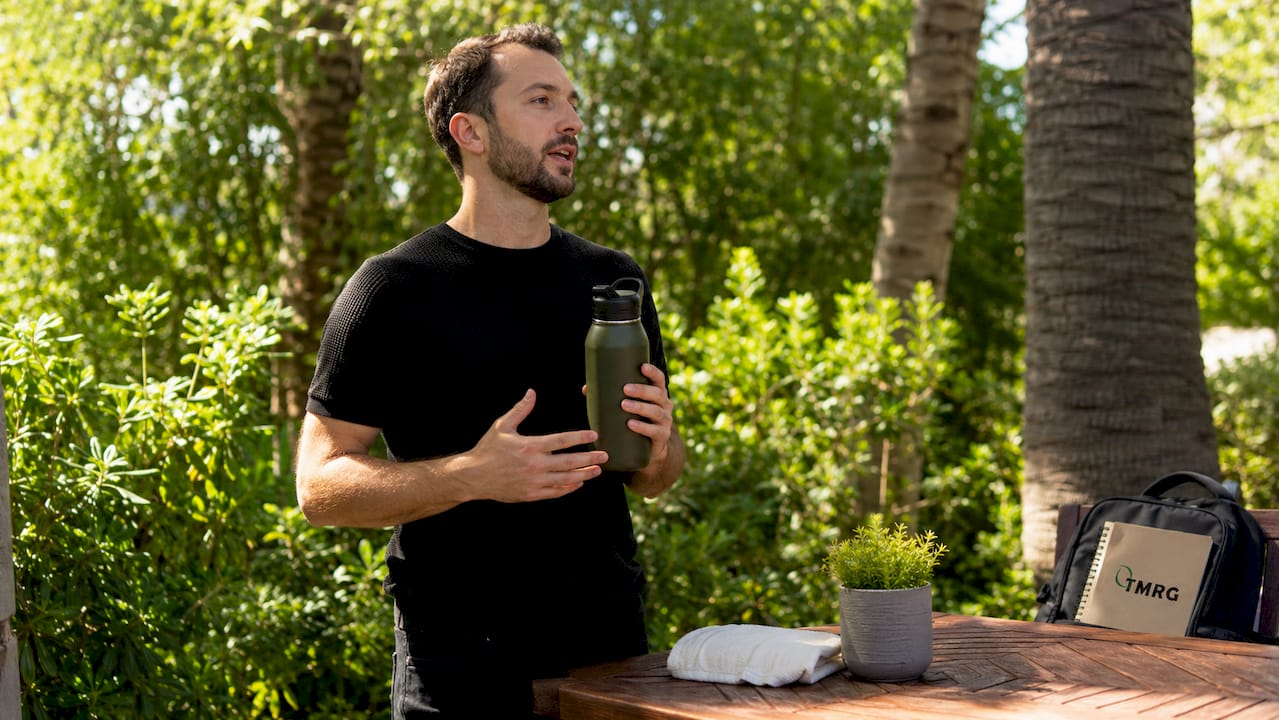 Hands holding water bottle by microphone in studio