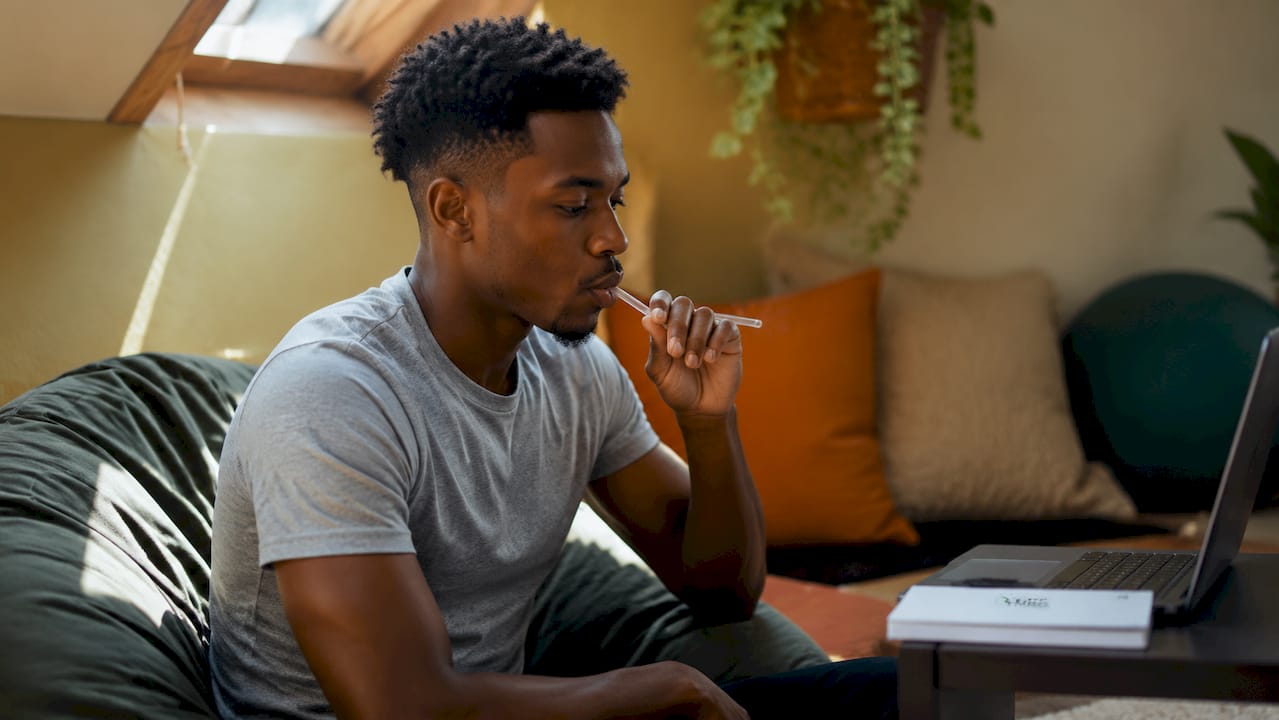 Close-up man performing vocal straw exercise