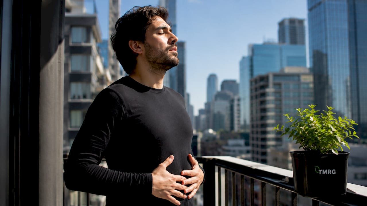 Man demonstrating diaphragmatic breath support in studio