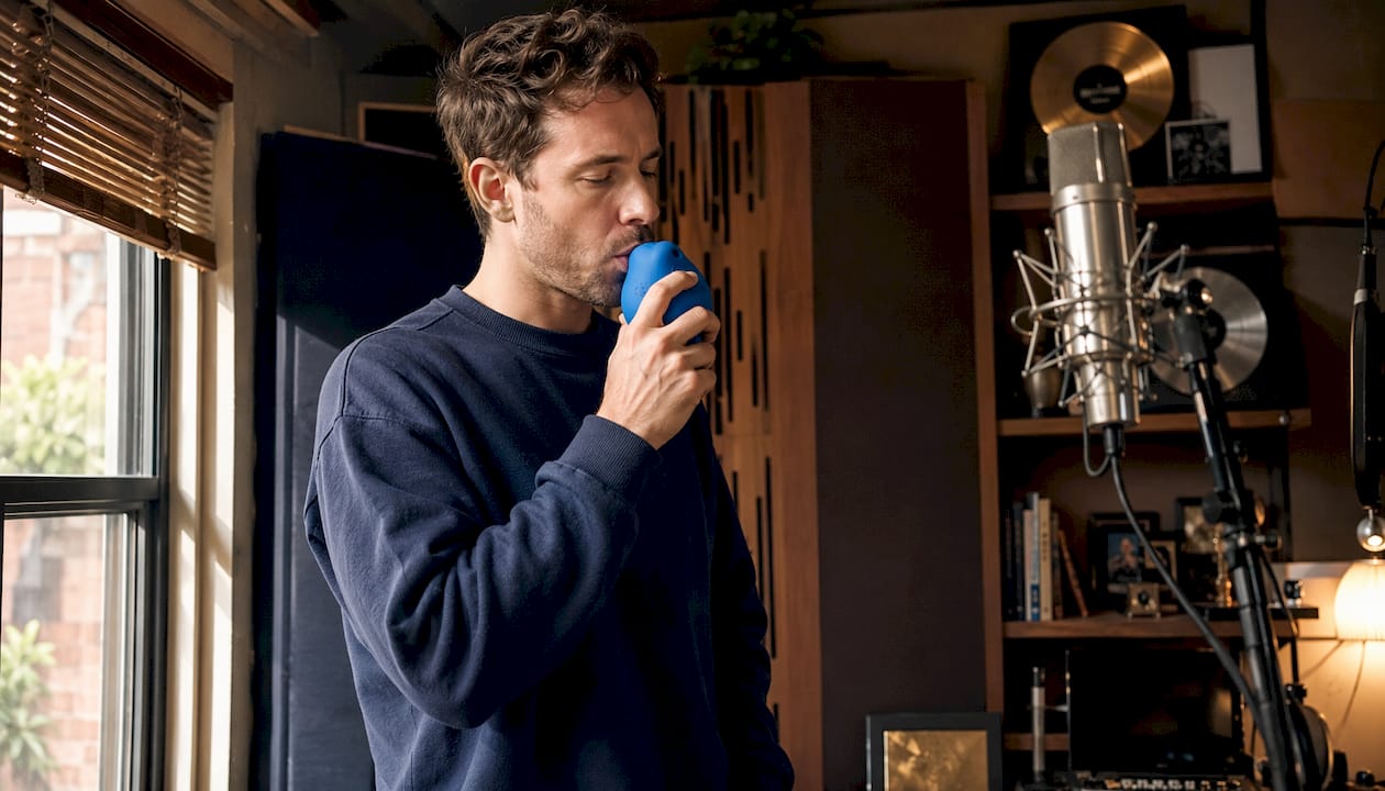 Man using handheld vocal humidifier in studio