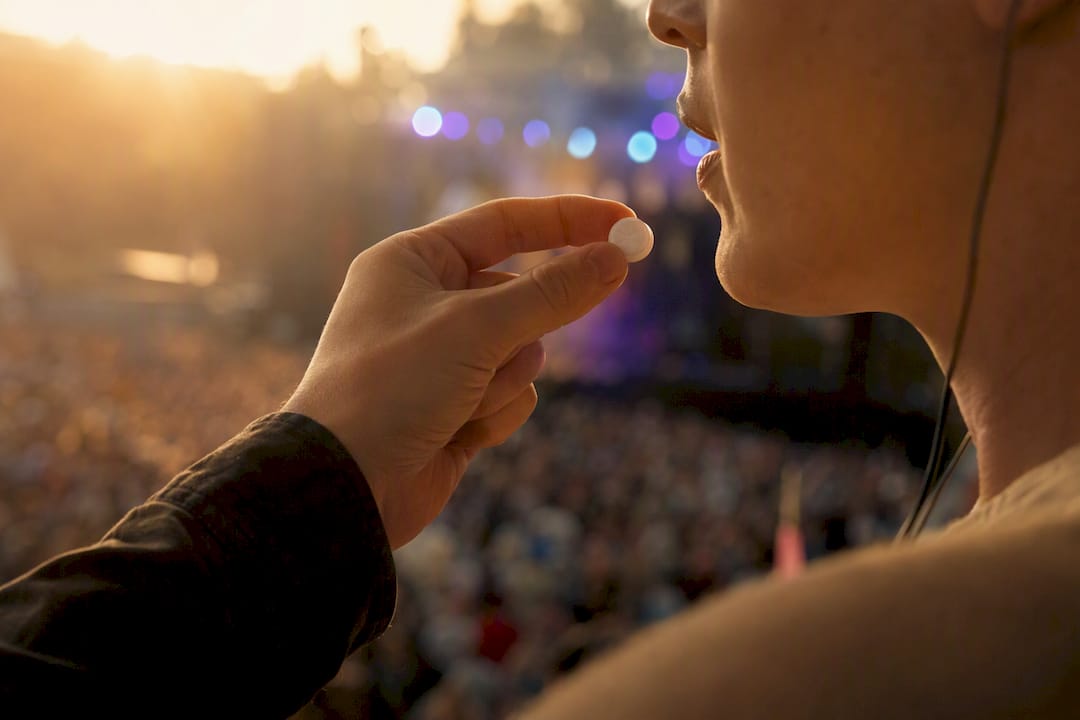 Hand holding slow dissolve lozenge near mouth