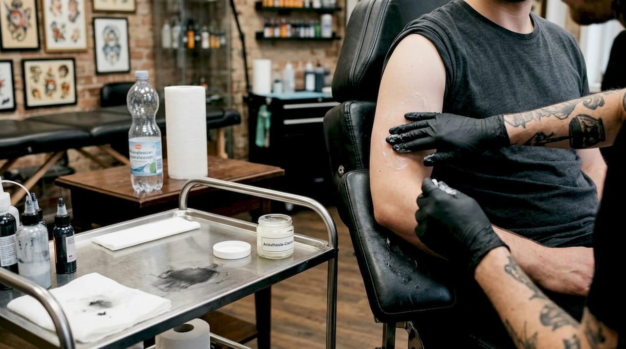 Bevor das Stechen beginnt, trägt der Tätowierer eine betäubende Creme auf, um die Schmerzen zu lindern.