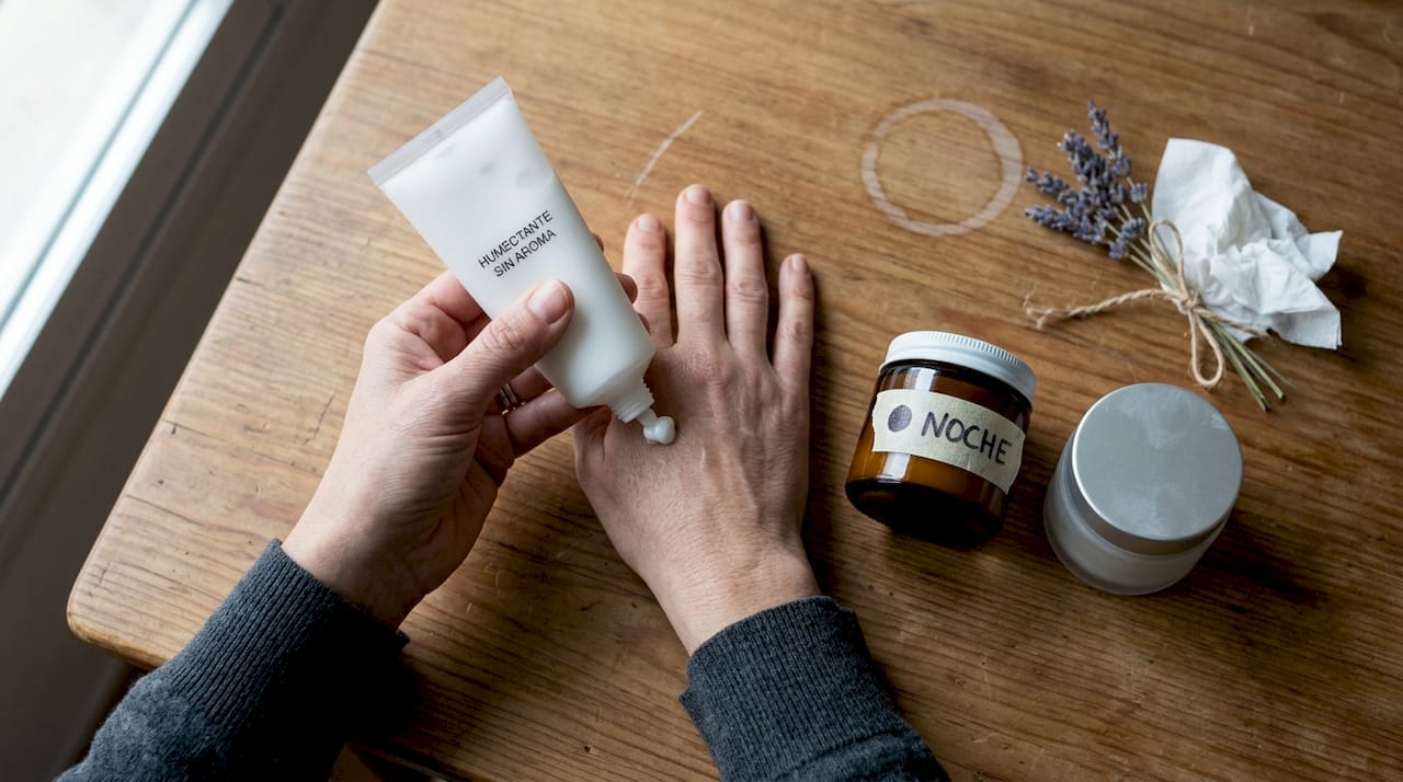 Detalle de unas manos aplicando una crema hidratante con ingredientes seguros