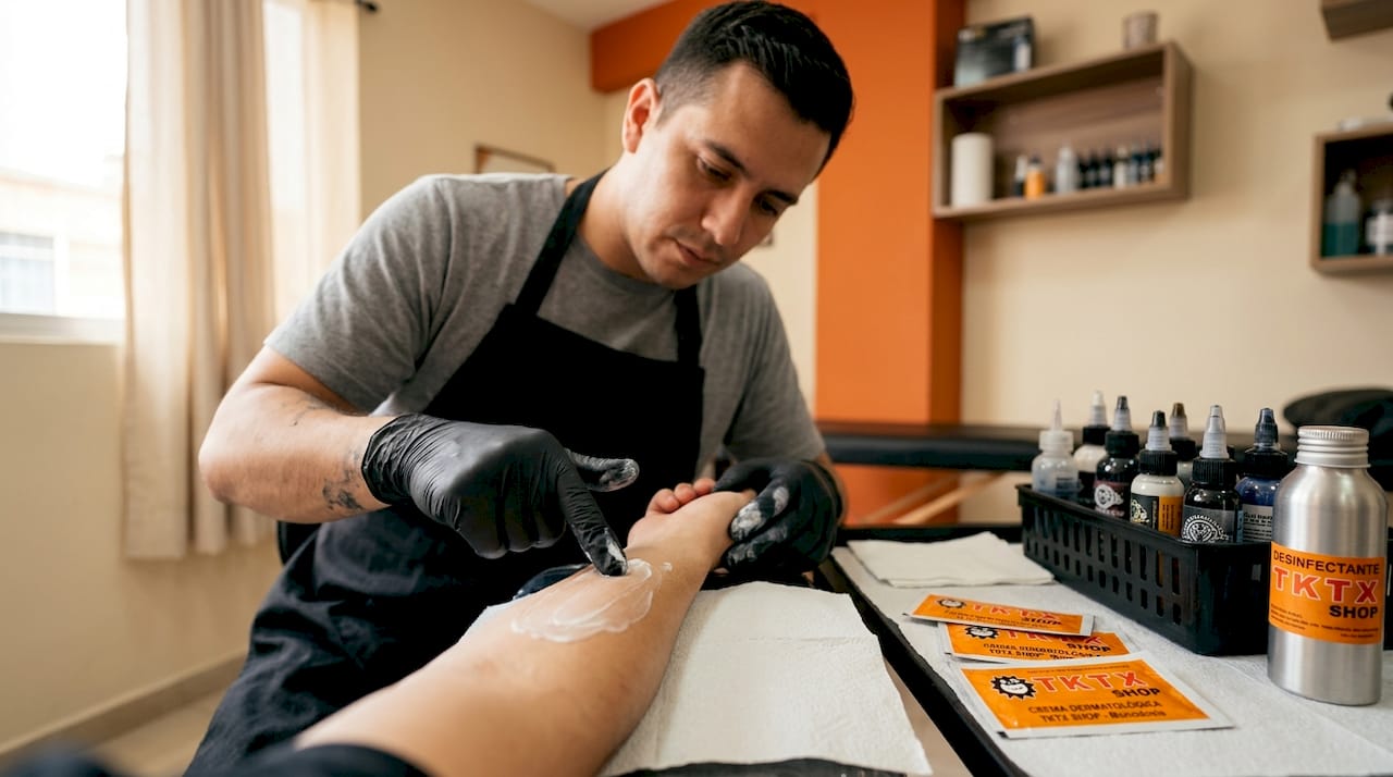 El tatuador prepara una crema previamente probada para aplicar durante el proceso.